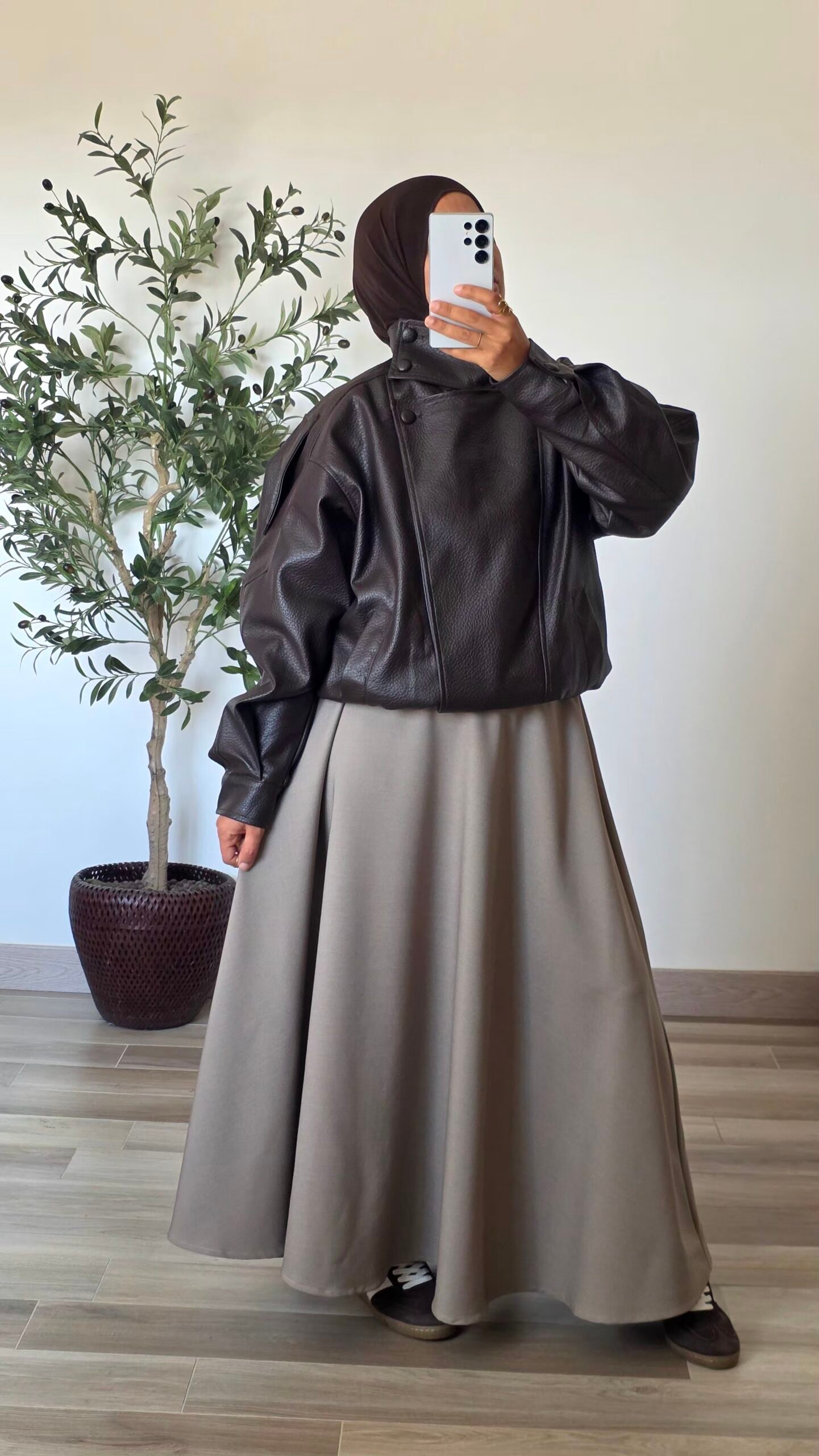 Femme portant une veste oversize en simili-cuir marron à col montant