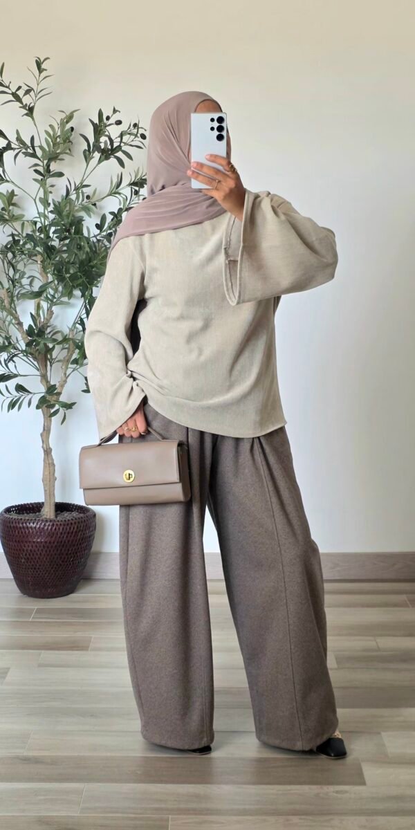 Femme portant une blouse en velours crème, coupe ample et manches longues