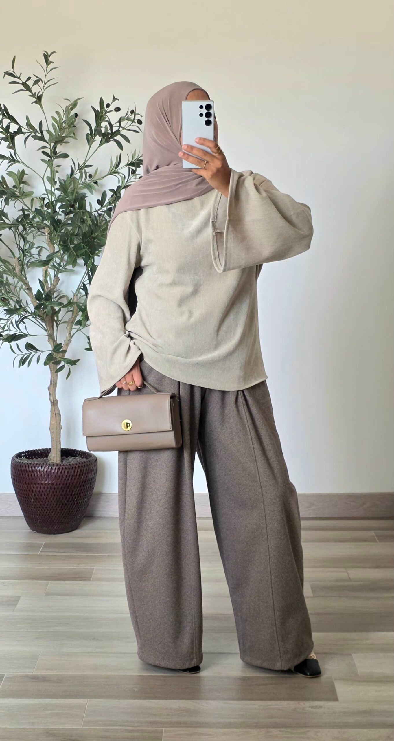 Femme portant une blouse en velours crème, coupe ample et manches longues