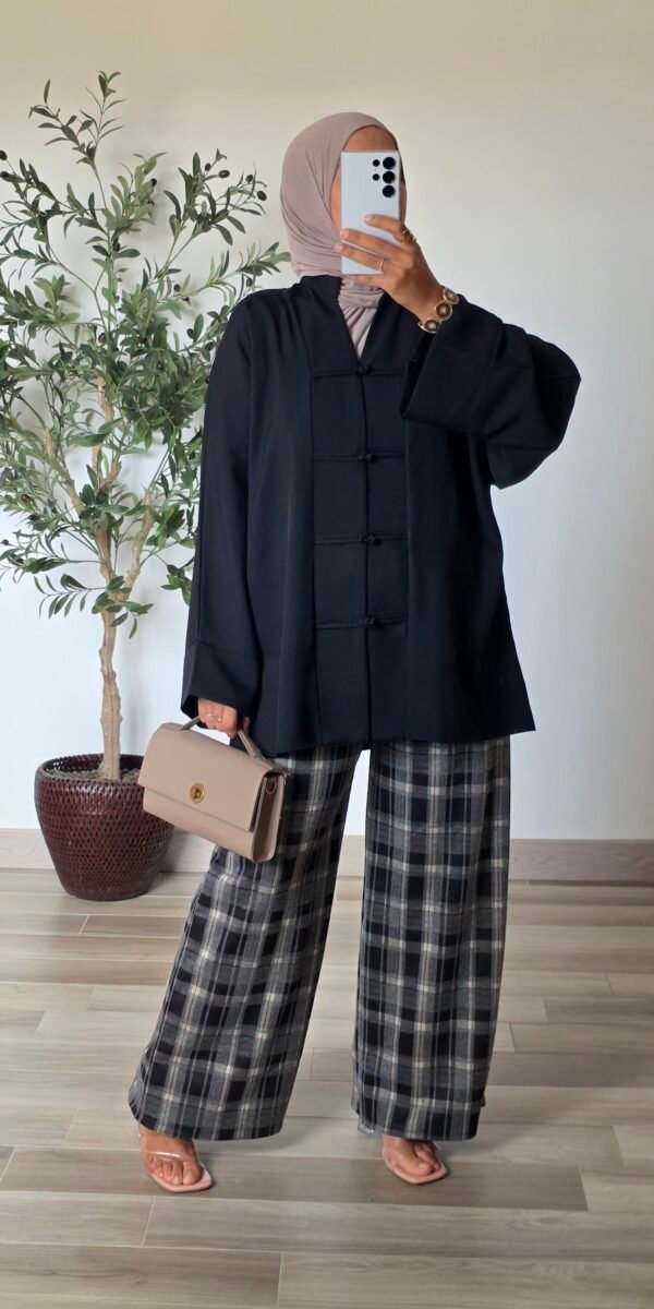 Pantalon large à carreaux noir pour femme, porté avec un haut uni