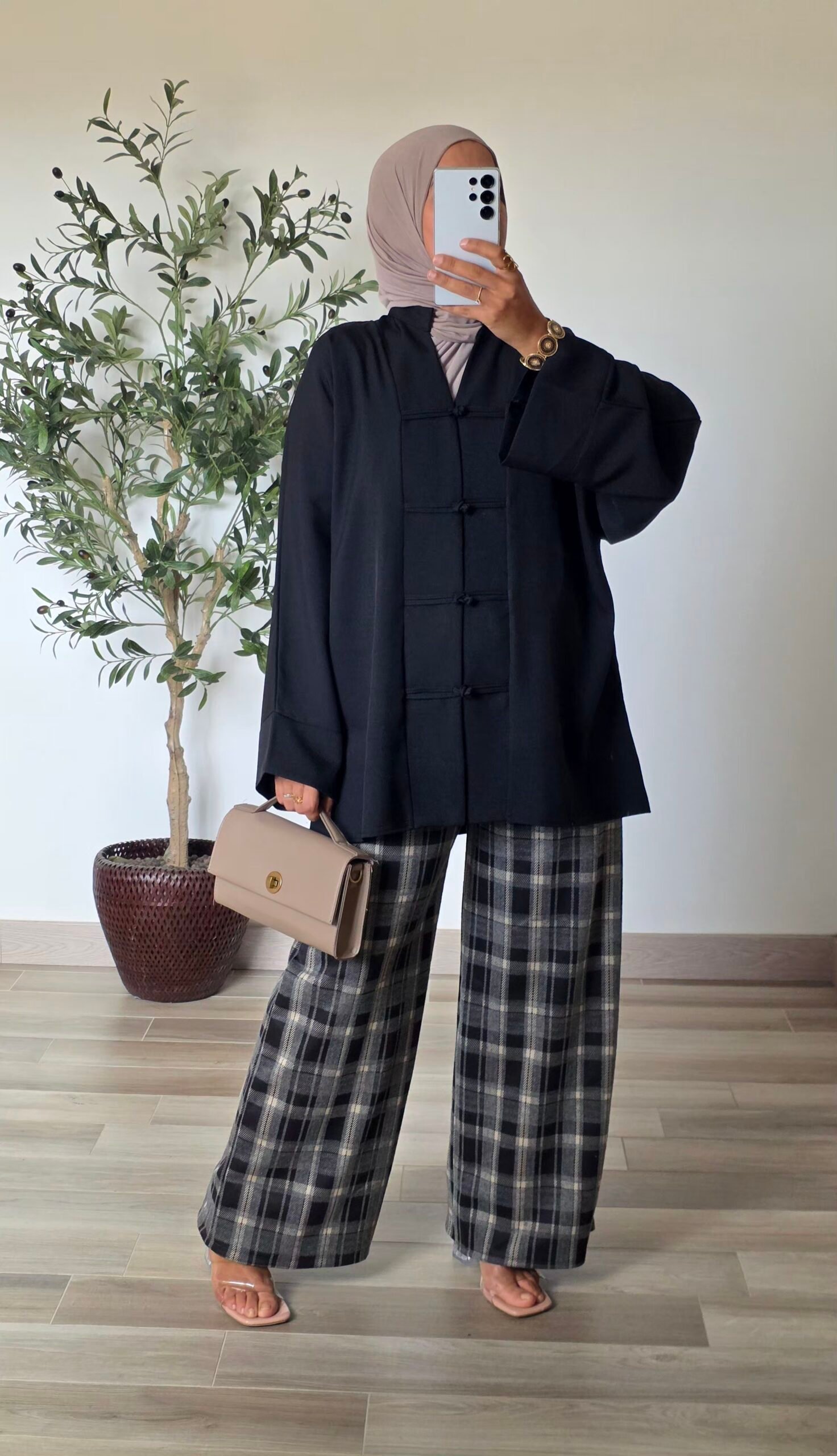 Pantalon large à carreaux noir pour femme, porté avec un haut uni