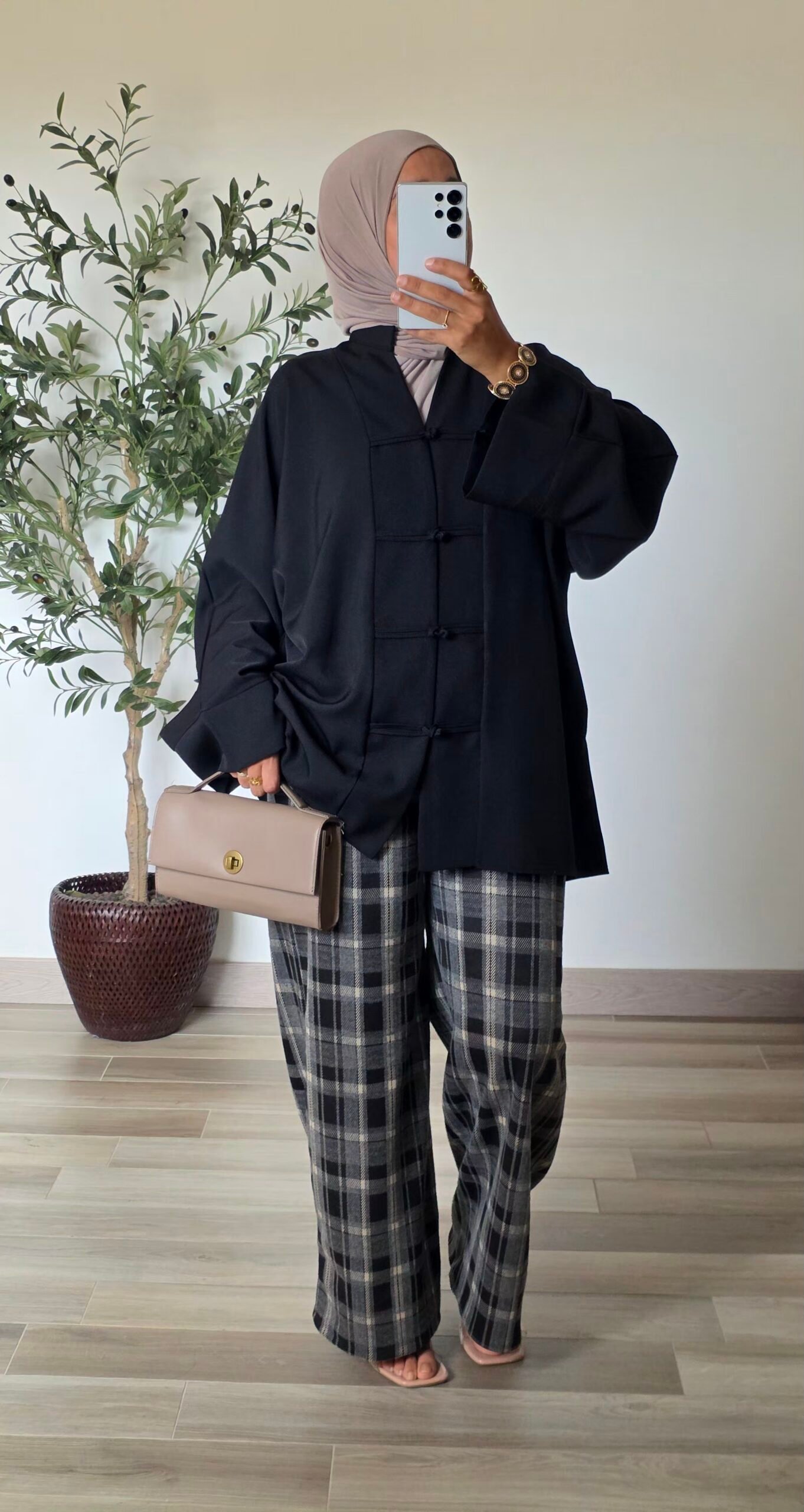 Pantalon large à carreaux noir pour femme, porté avec un haut uni
