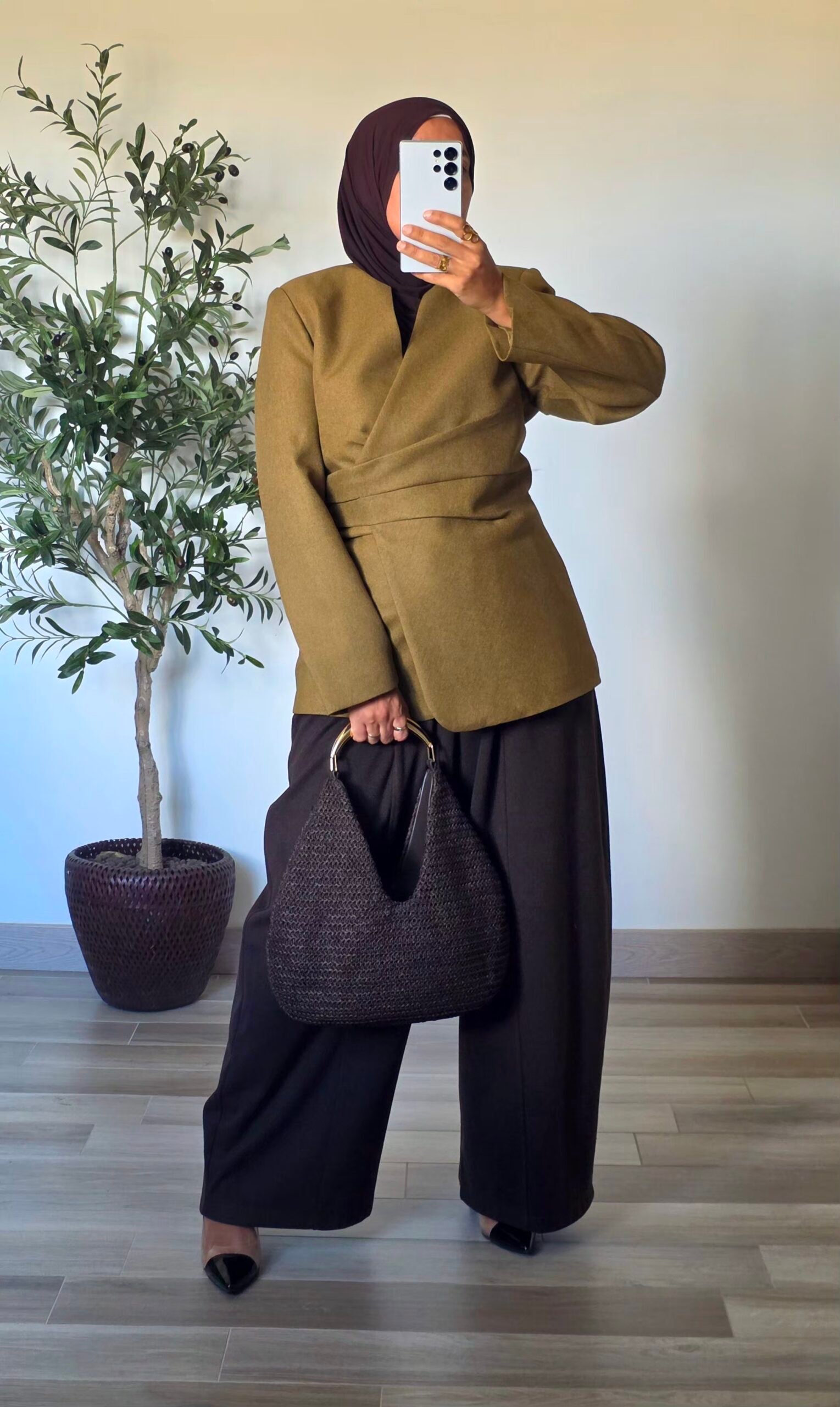 Femme portant un blazer vert olive chic à devant croisé et ceinture à nouer dans le dos