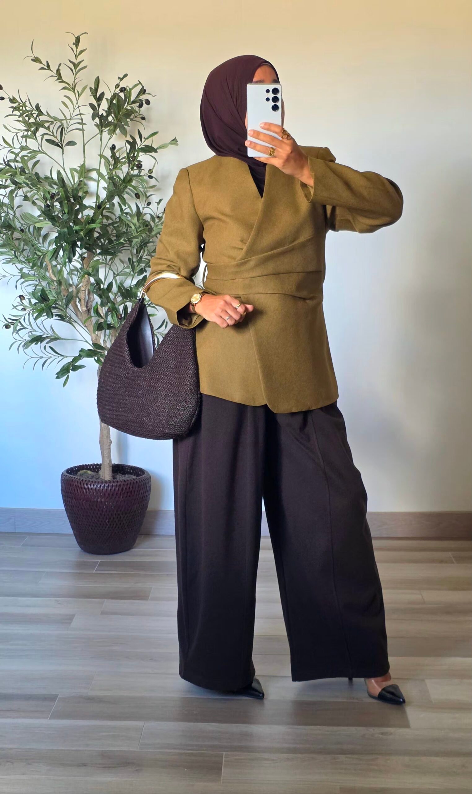 Femme portant un blazer vert olive chic à devant croisé et ceinture à nouer dans le dos