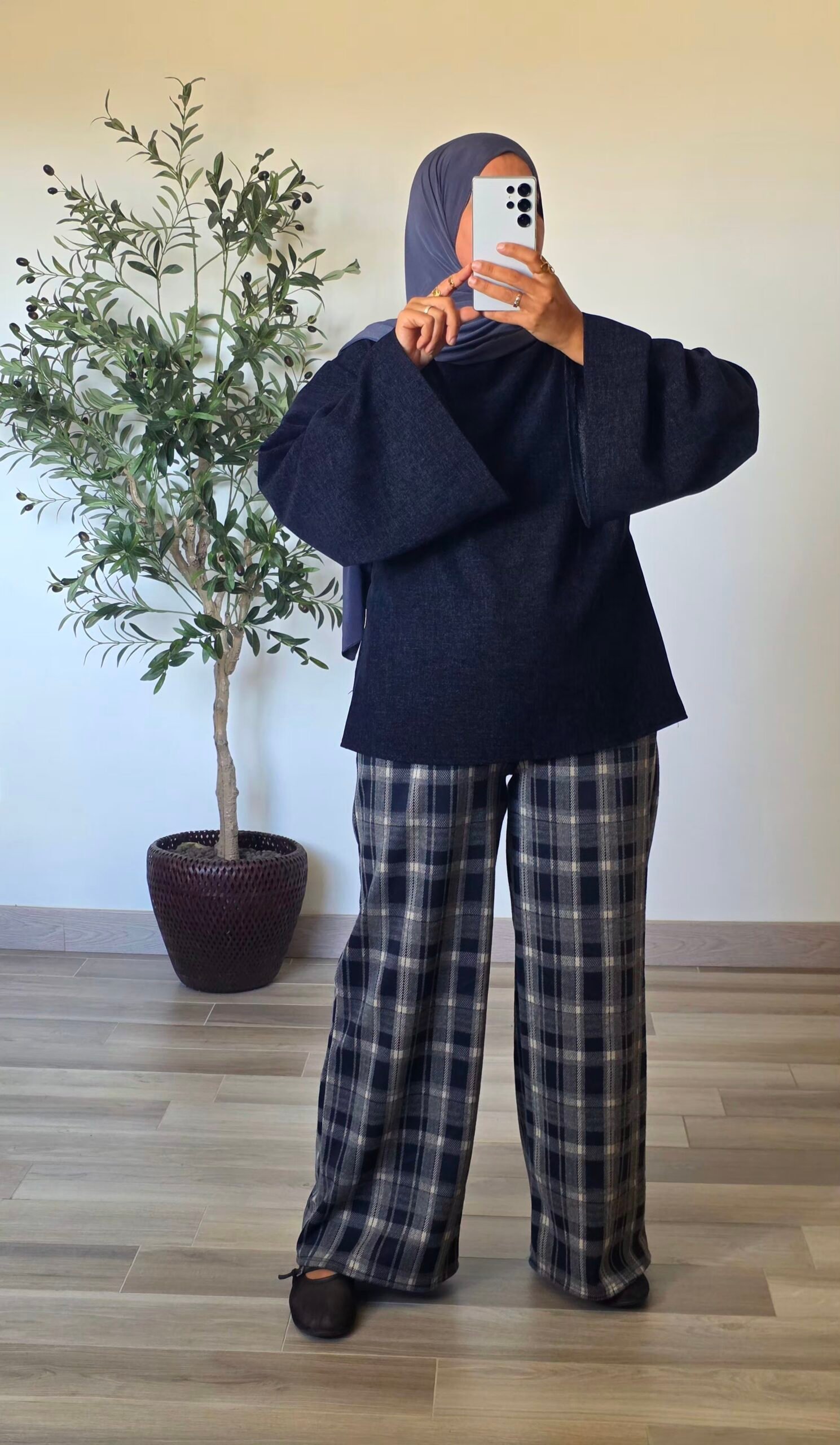 Pantalon large à carreaux bleu marine pour femme, porté avec un haut uni
