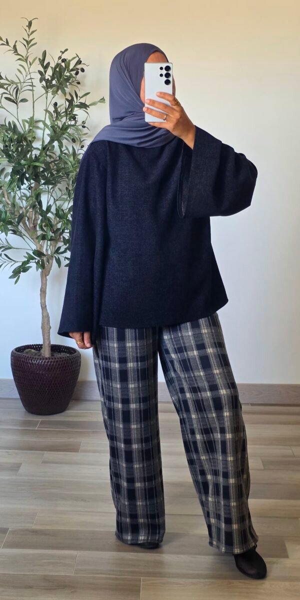 Femme portant une blouse en velours bleu marine, coupe ample et manches longues