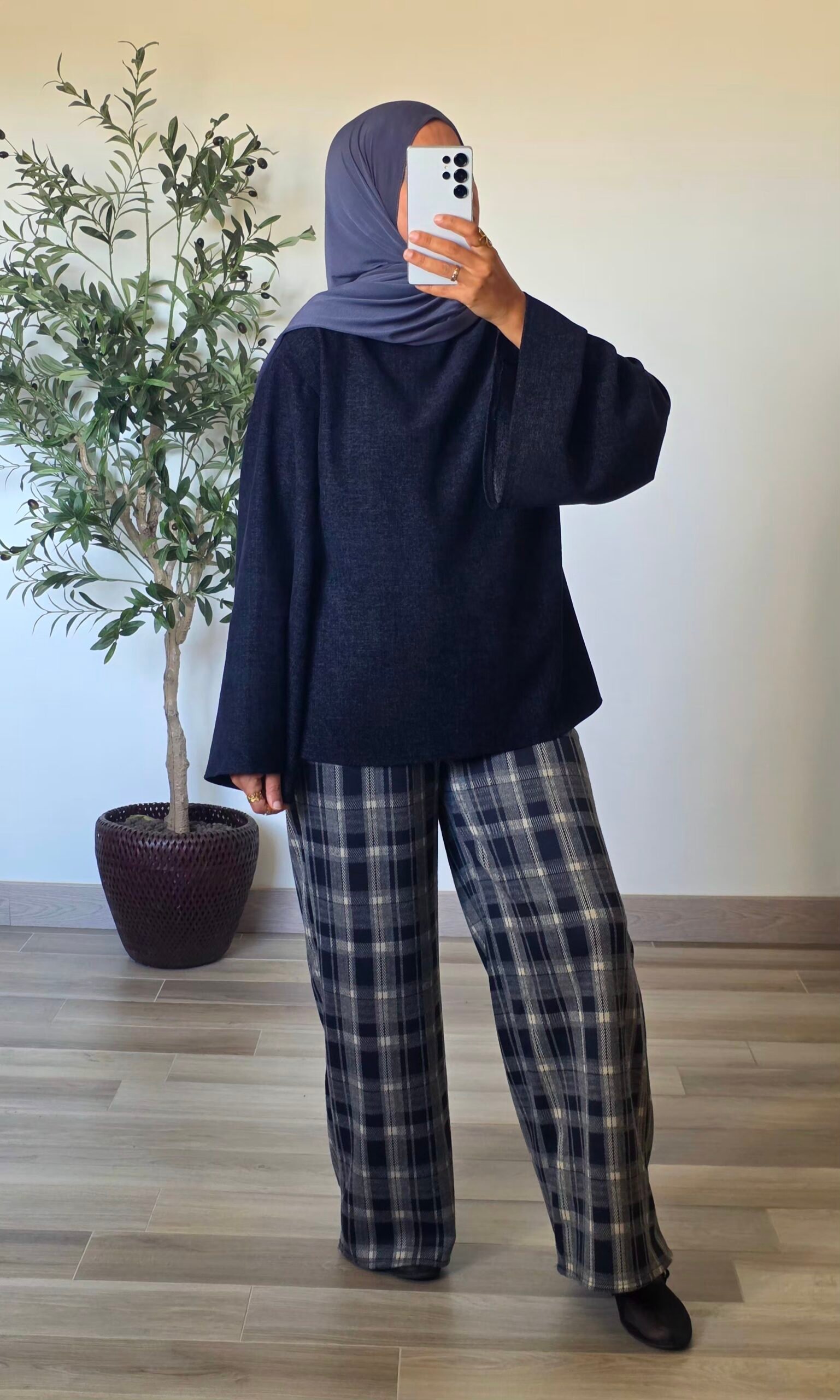 Pantalon large à carreaux bleu marine pour femme, porté avec un haut uni