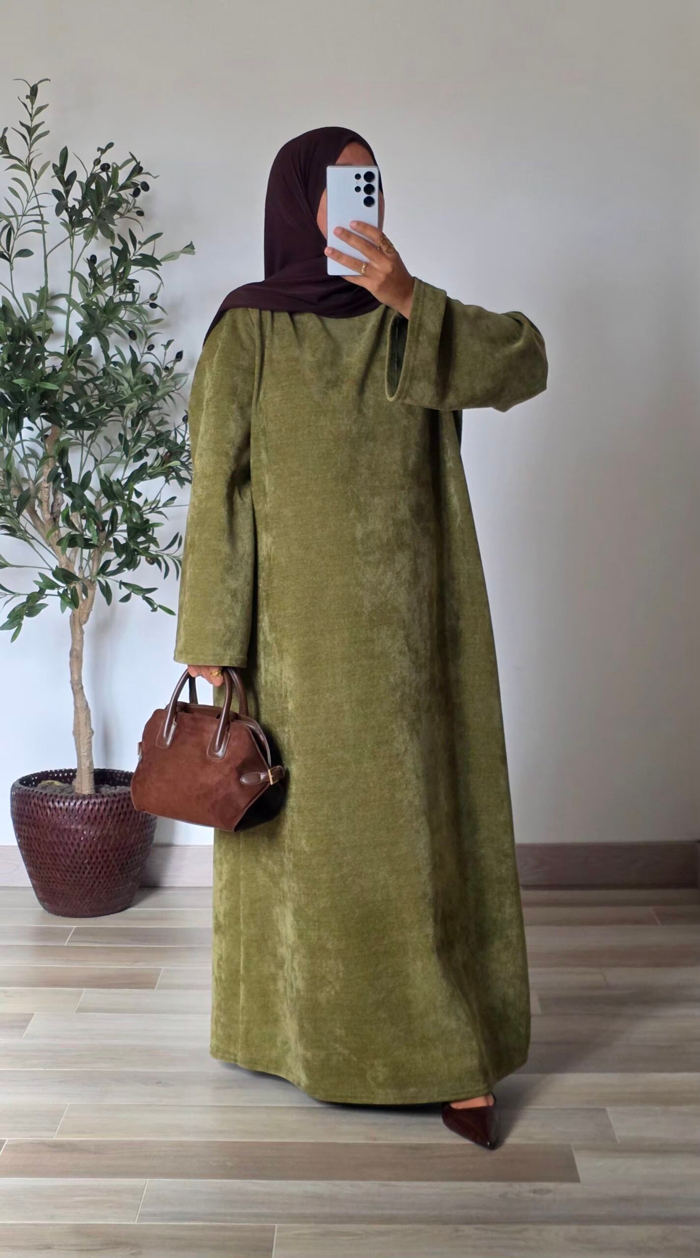 Femme portant une robe longue en velours vert olive à manches longues