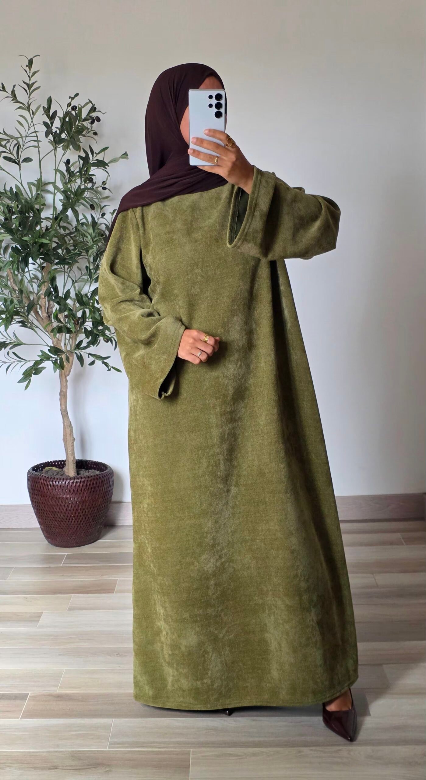 Femme portant une robe longue en velours vert olive à manches longues