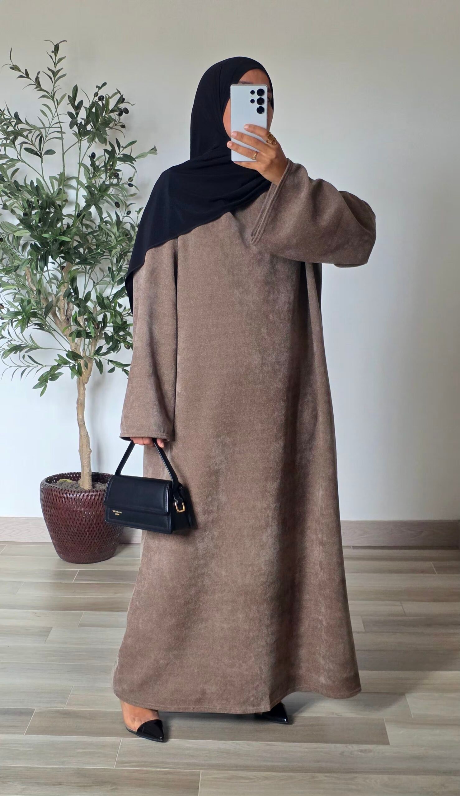 Femme portant une robe longue en velours taupe à manches longues