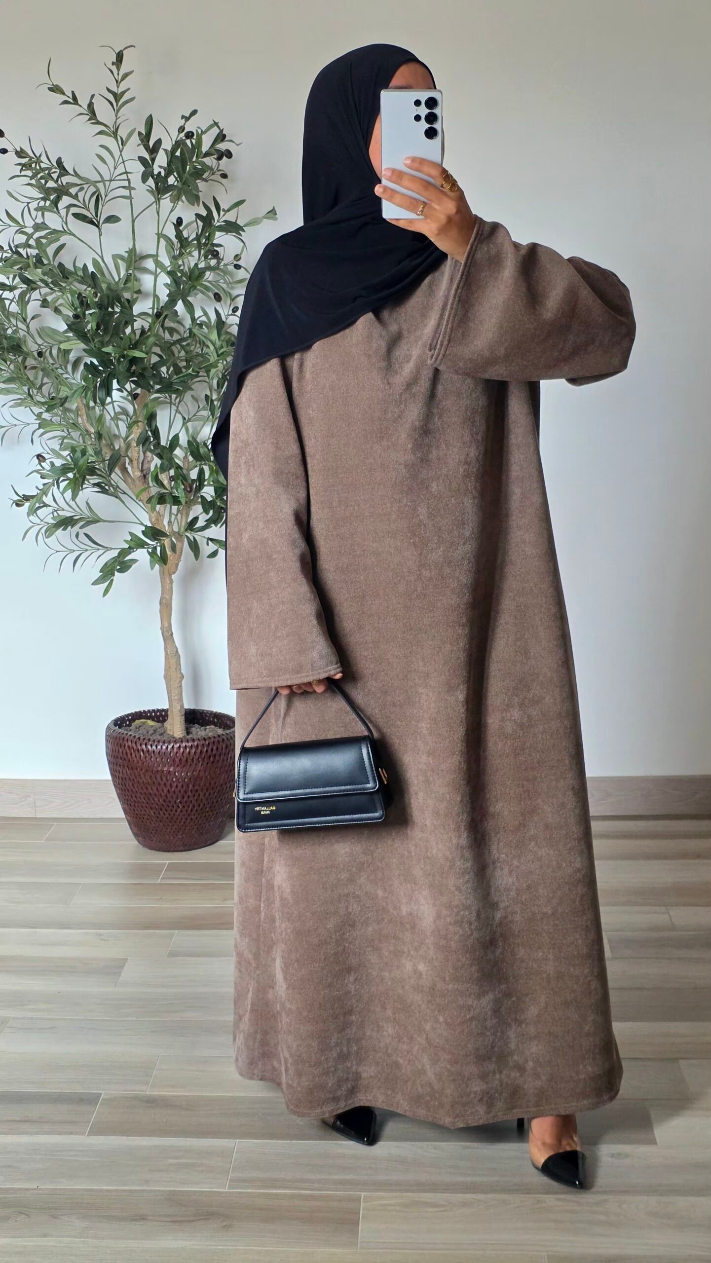 Femme portant une robe longue en velours taupe à manches longues