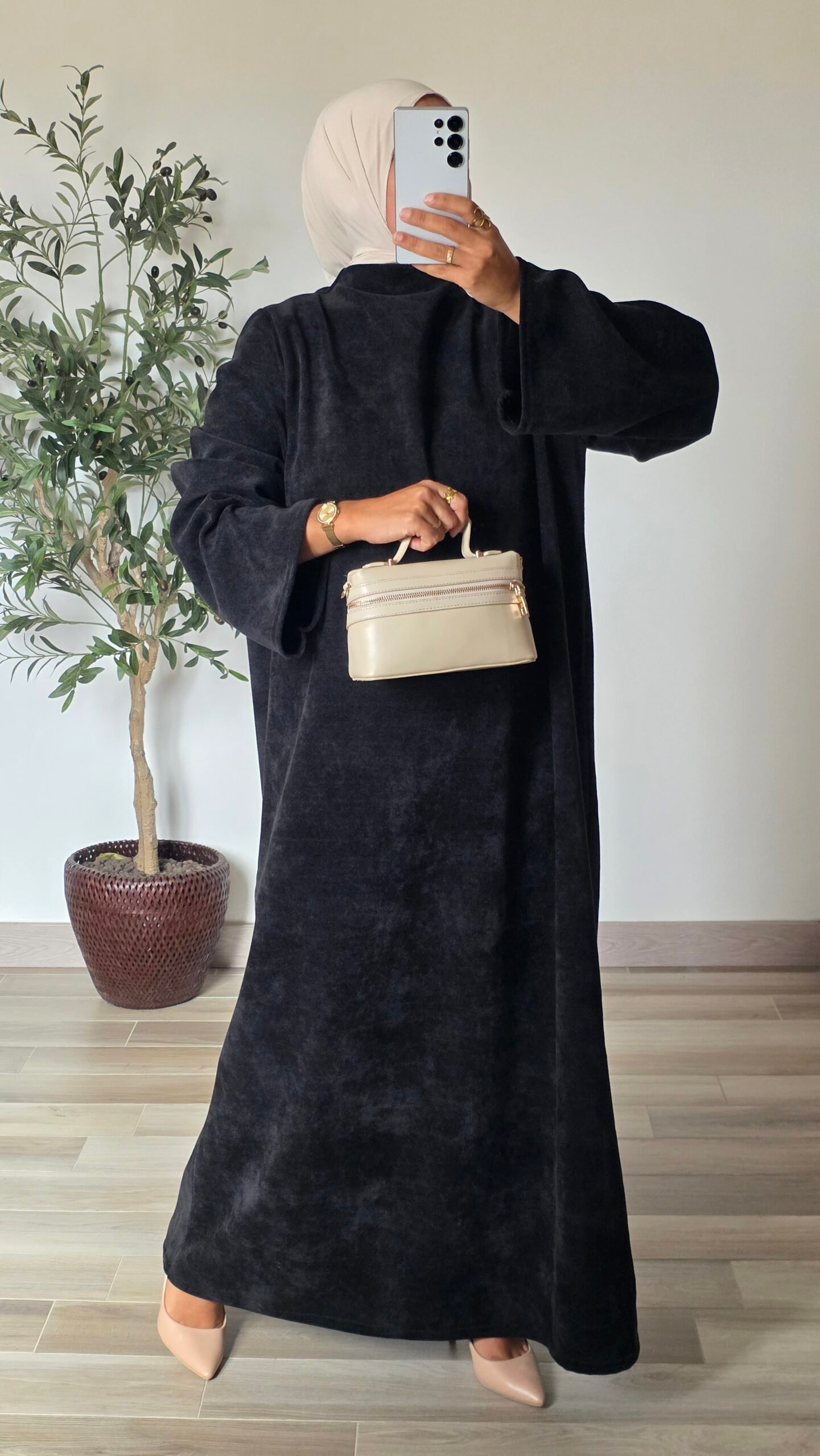 Femme portant une robe longue en velours noir à manches longues