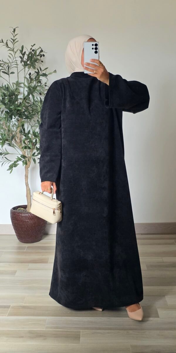 Femme portant une robe longue en velours noir à manches longues