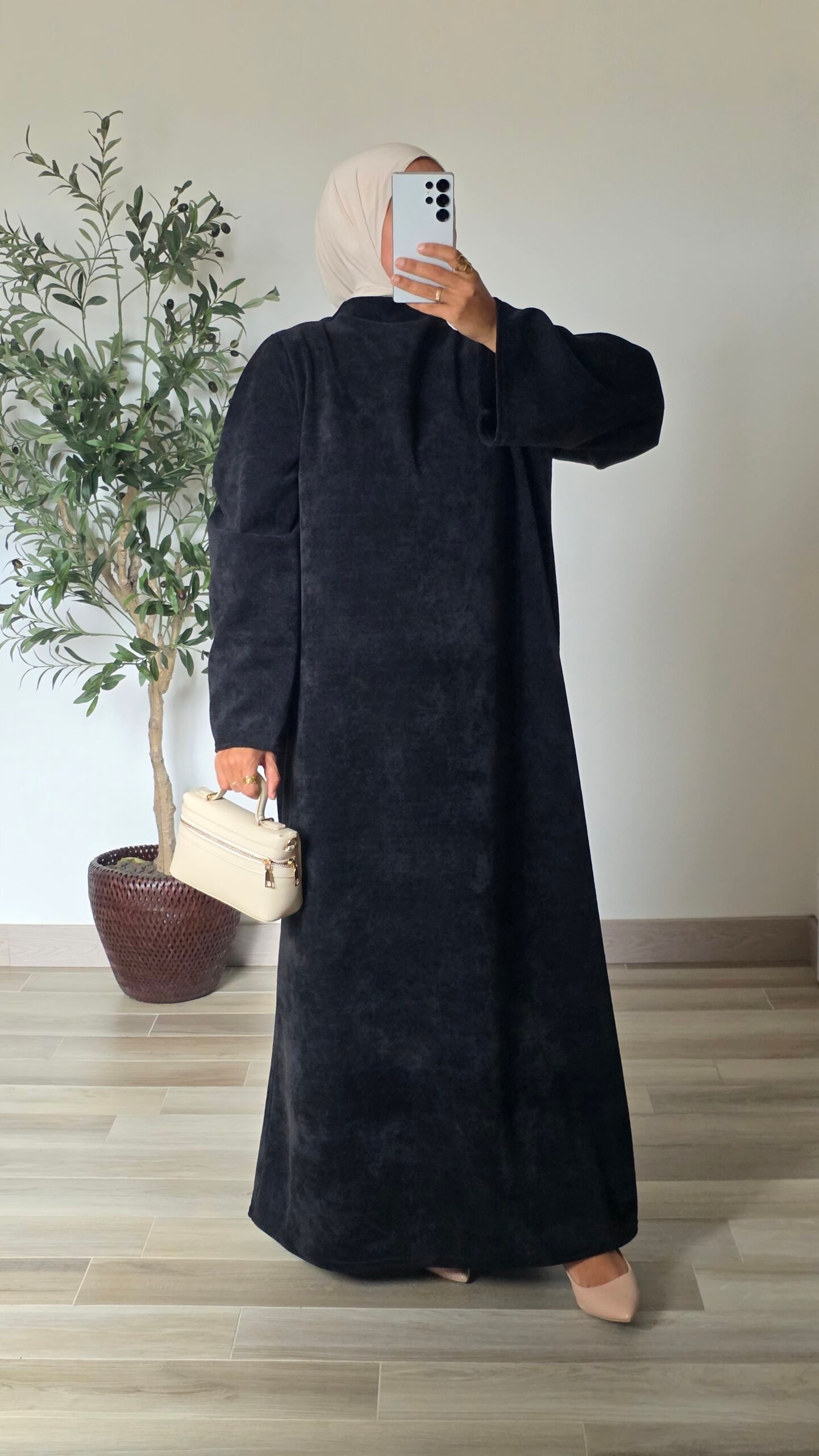 Femme portant une robe longue en velours noir à manches longues