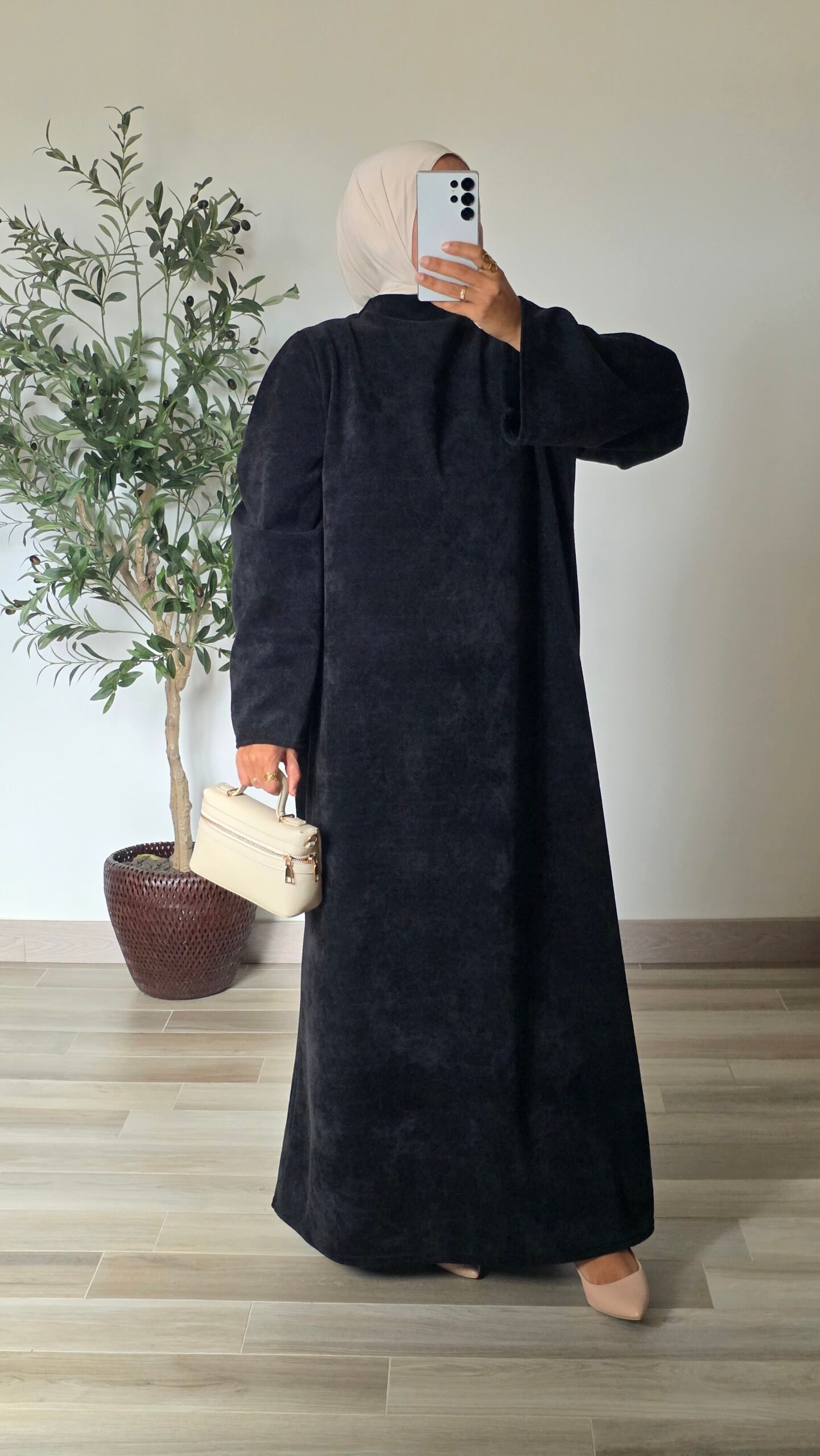 Femme portant une robe longue en velours noir à manches longues