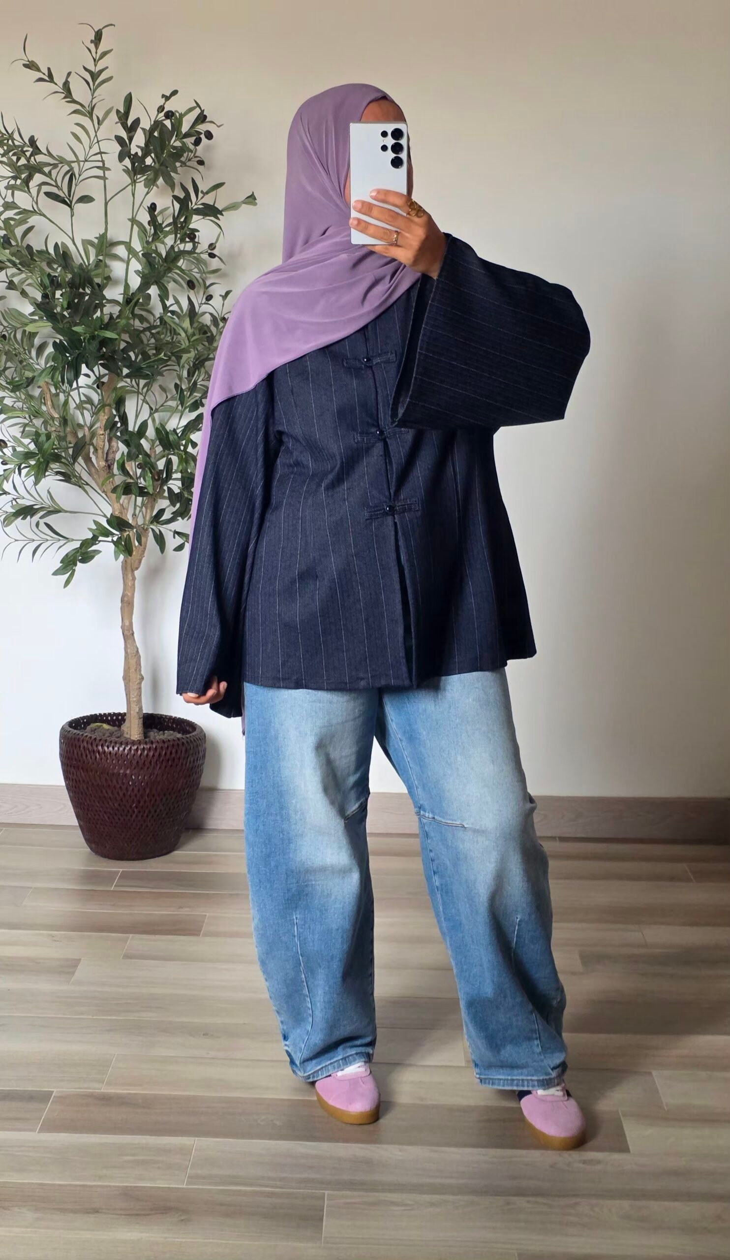 Femme portant une tunique oversize bleu marine à fines rayures, col mao et manches larges