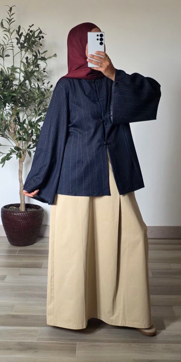 Femme portant une tunique oversize bleu marine à fines rayures, col mao et manches larges