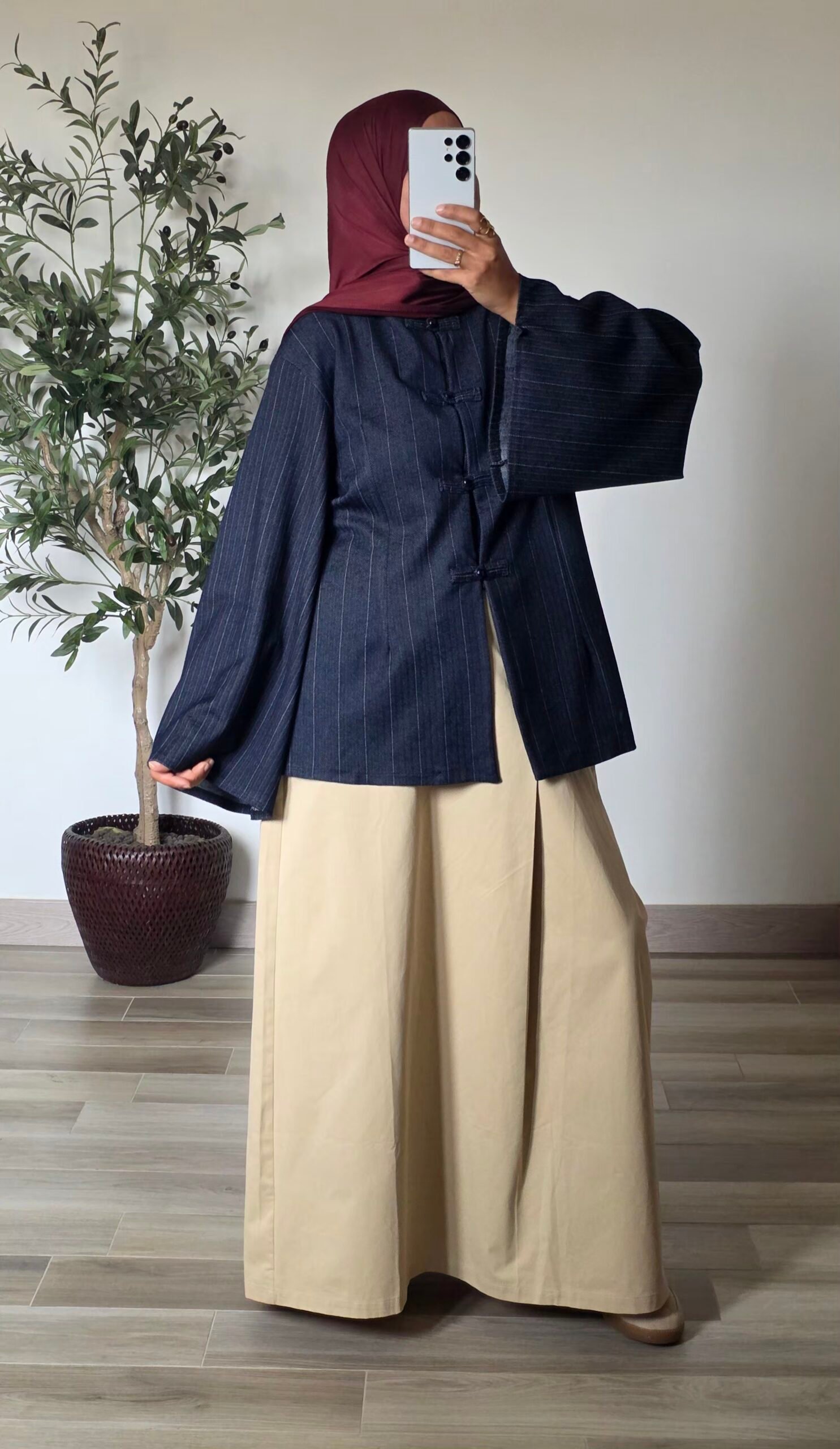 Femme portant une tunique oversize bleu marine à fines rayures, col mao et manches larges