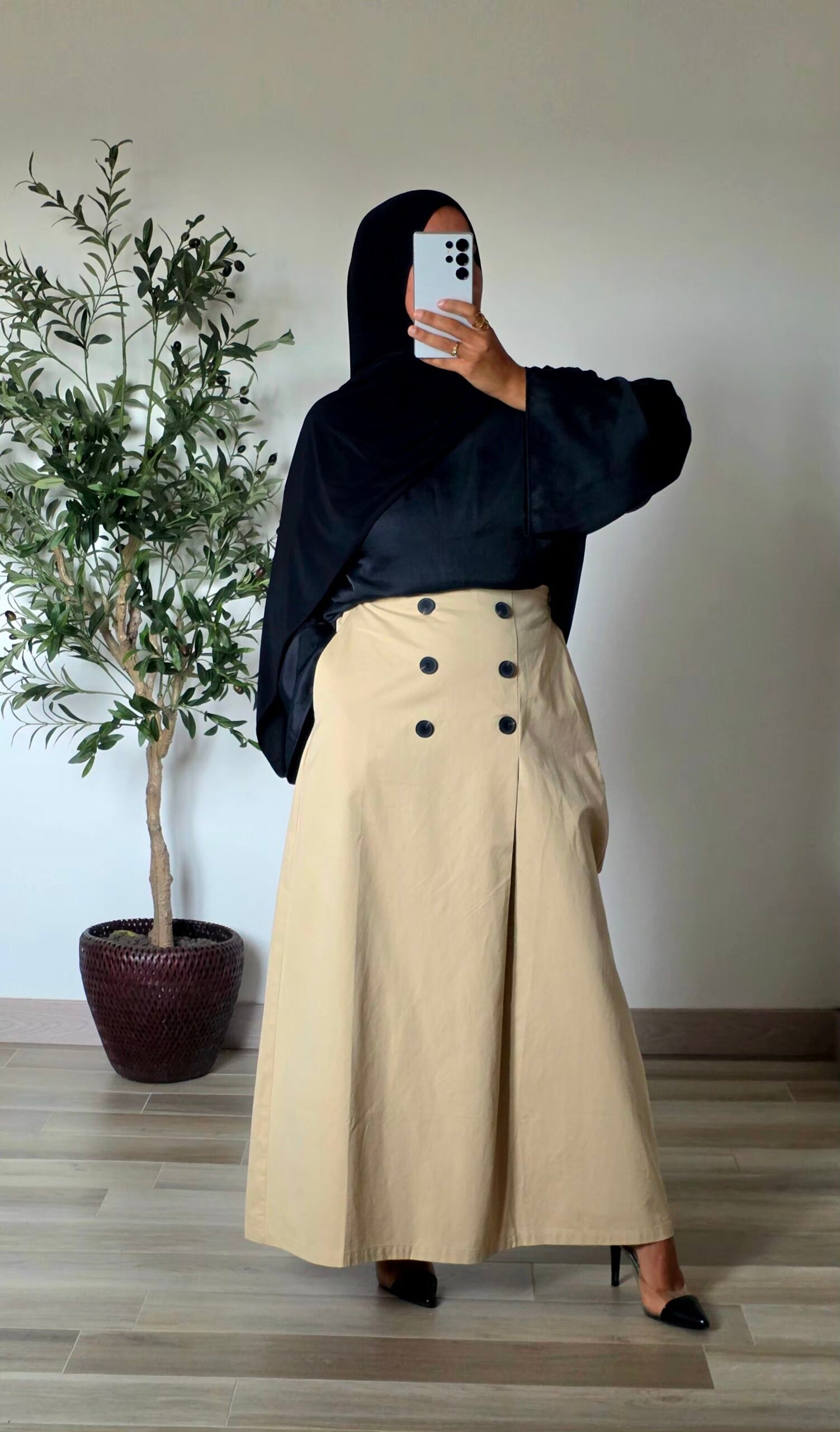 Femme portant une jupe longue trapèze beige en coton avec boutons sur le devant