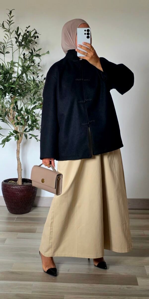 Femme portant un manteau court noir effet laine à col montant et quatre attaches chinoises