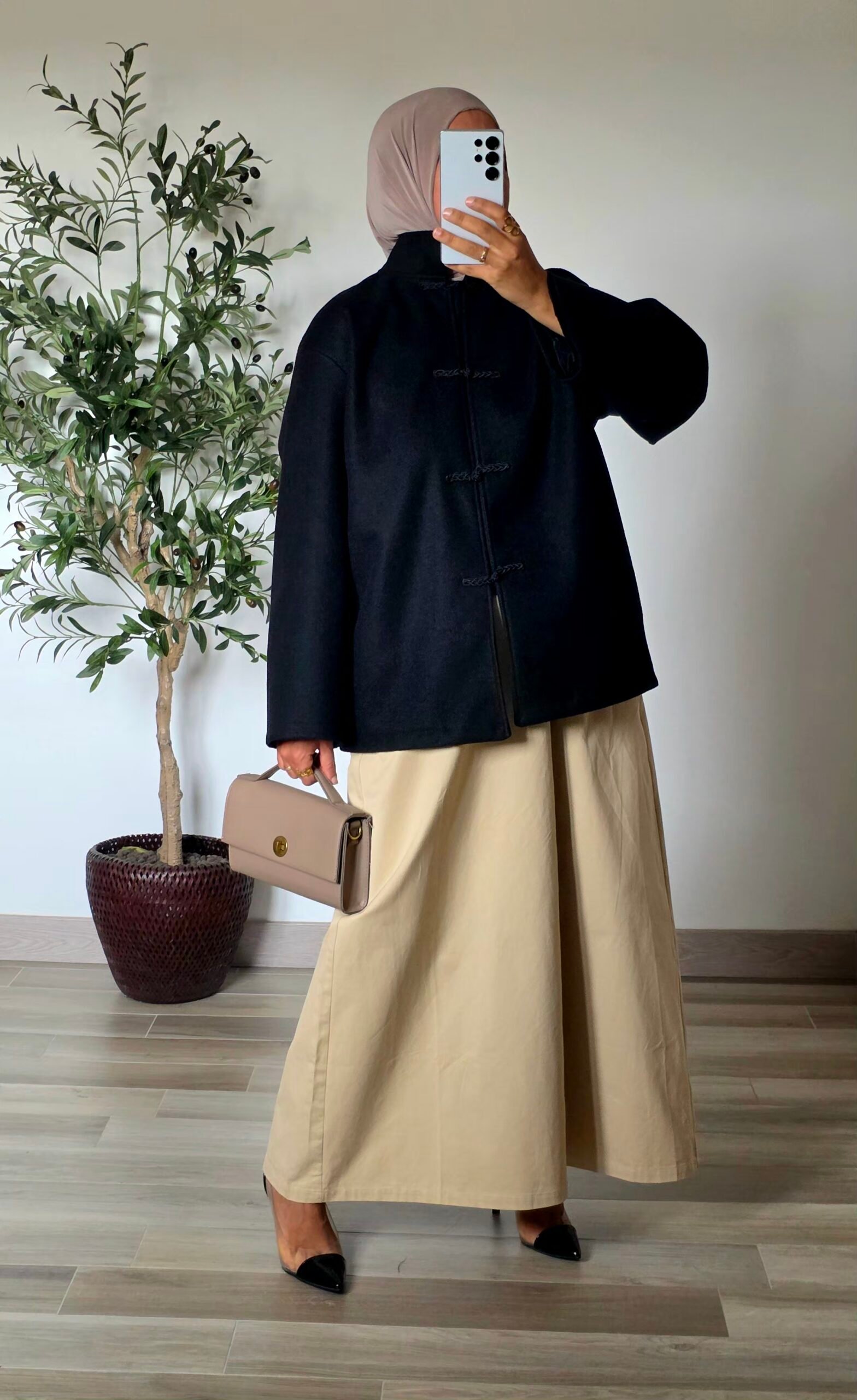 Femme portant un manteau court noir effet laine à col montant et quatre attaches chinoises