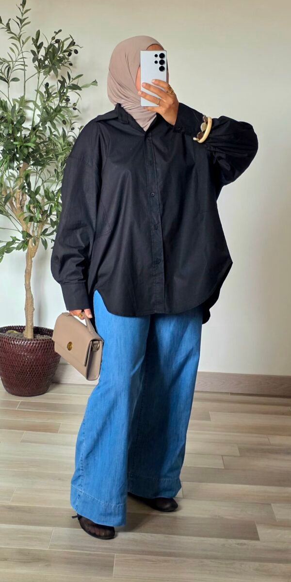 Femme portant une chemise longue oversize noire en coton avec une jupe longue noire