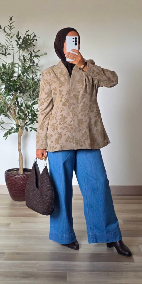 Femme portant une veste jacquard taupe à motifs floraux avec un jean large