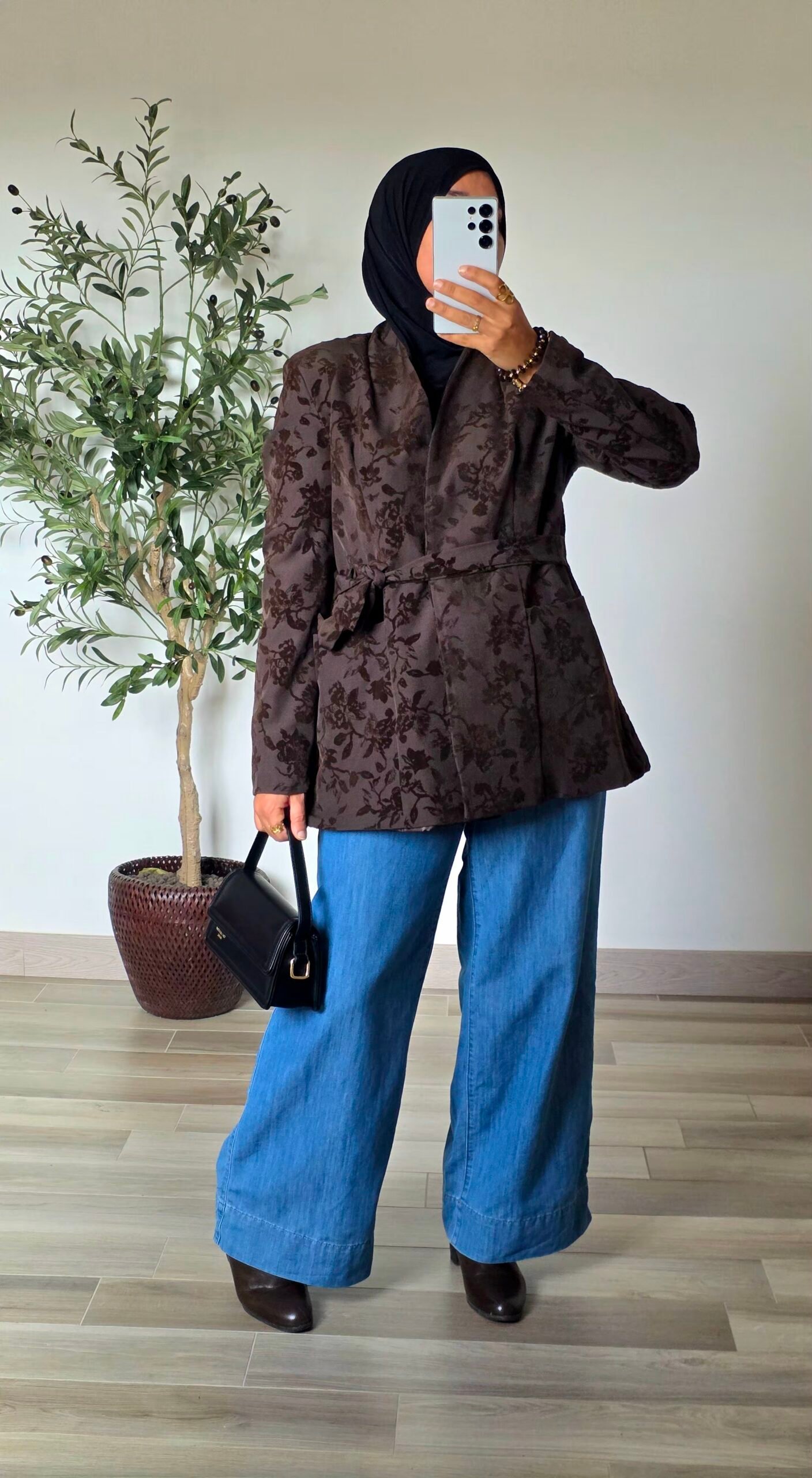 Femme portant une veste jacquard taupe à motifs floraux avec un jean large