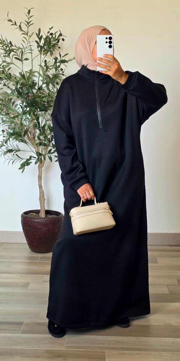Femme portant une robe longue sportswear noire à col montant zippé et coupe ample