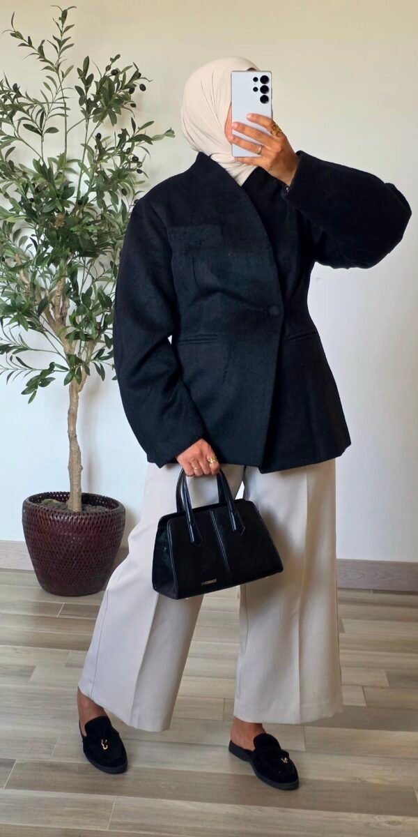 Femme portant un manteau blazer noir en laine mélangée, coupe structurée et manches longues