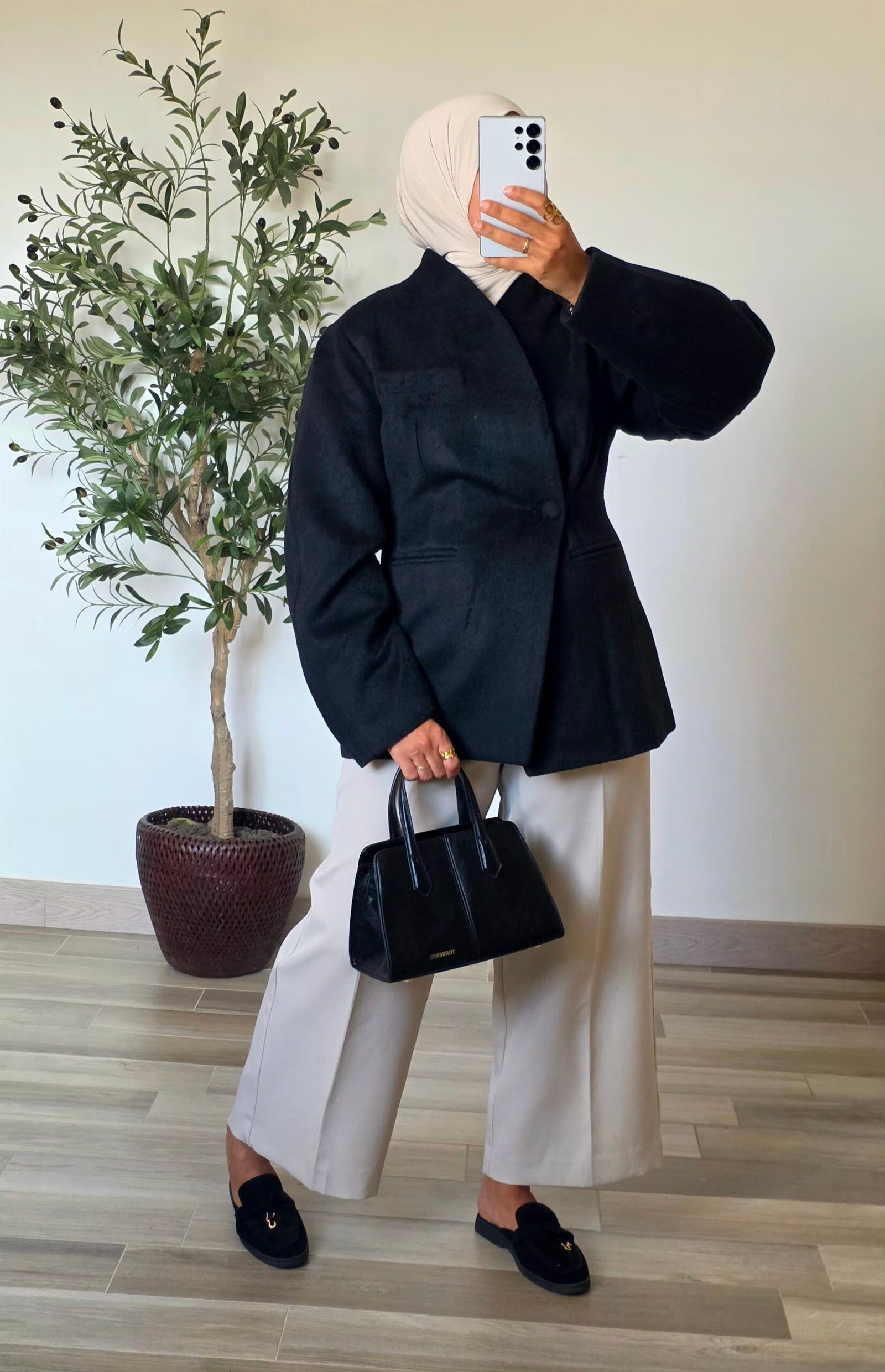 Femme portant un manteau blazer noir en laine mélangée, coupe structurée et manches longues