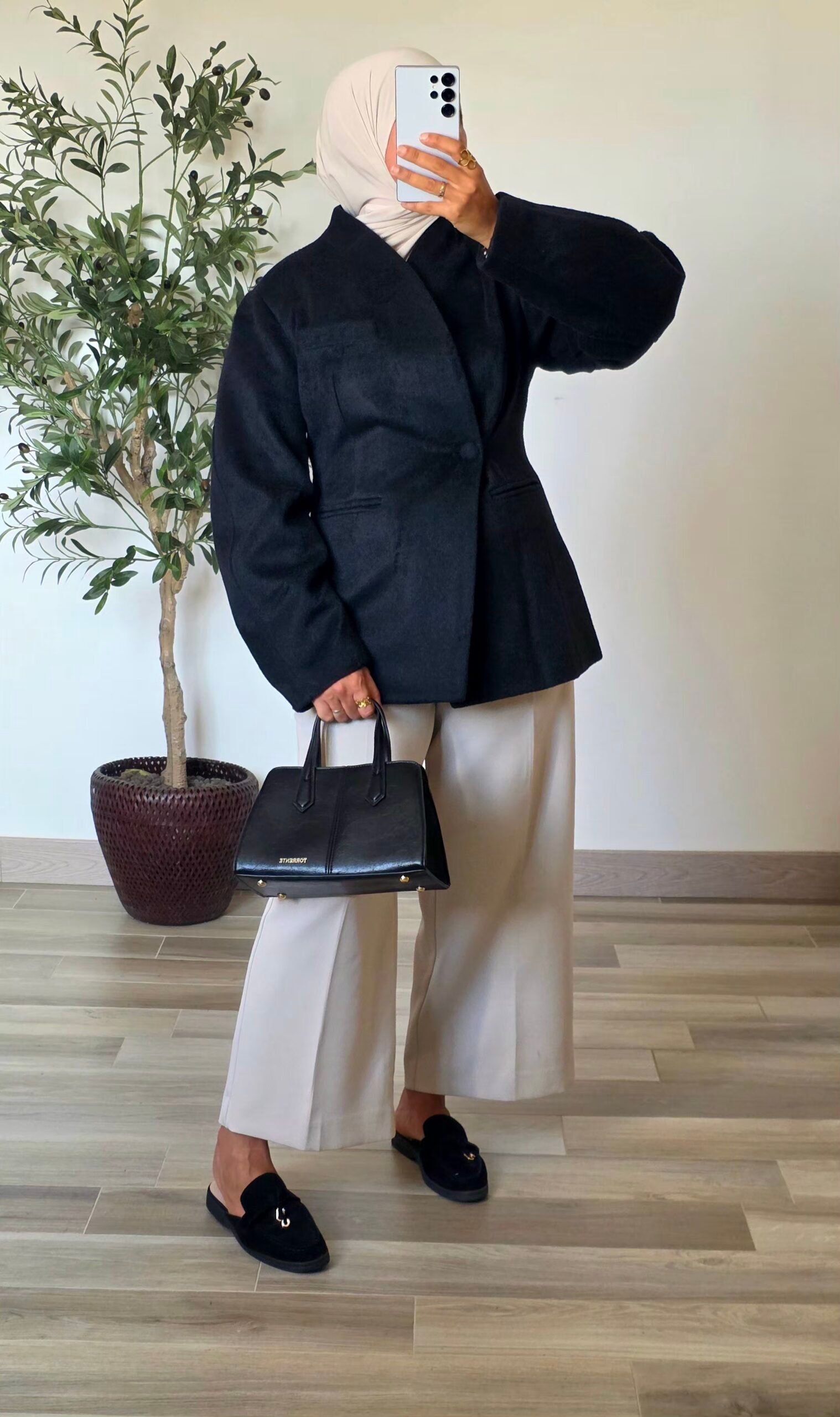 Femme portant un manteau blazer noir en laine mélangée, coupe structurée et manches longues