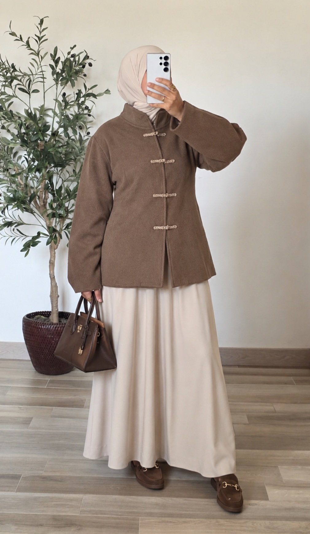 Femme portant un manteau court taupe effet laine à col montant et quatre attaches chinoises