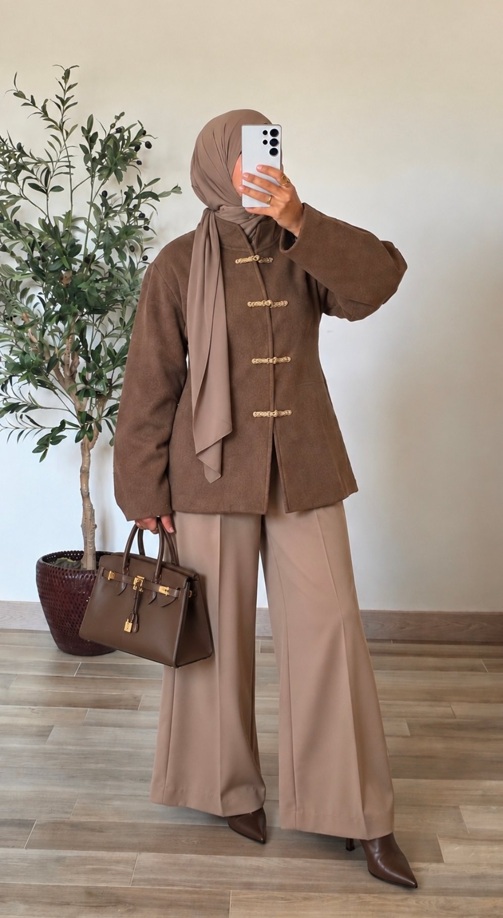 Femme portant un manteau court taupe effet laine à col montant et quatre attaches chinoises